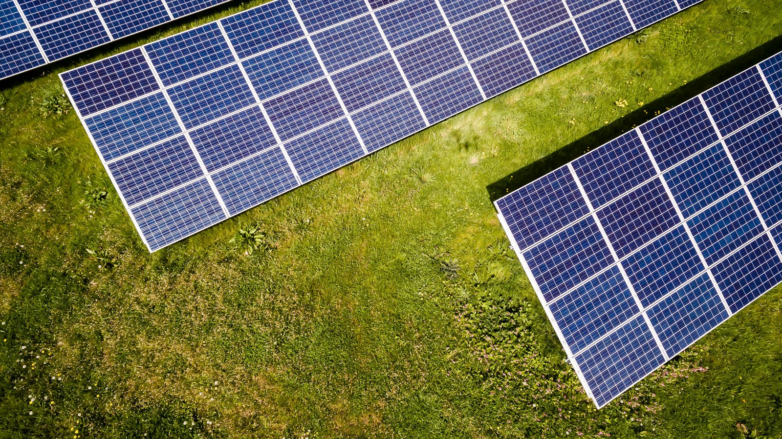 Tampak atas deretan panel surya di lahan terbuka